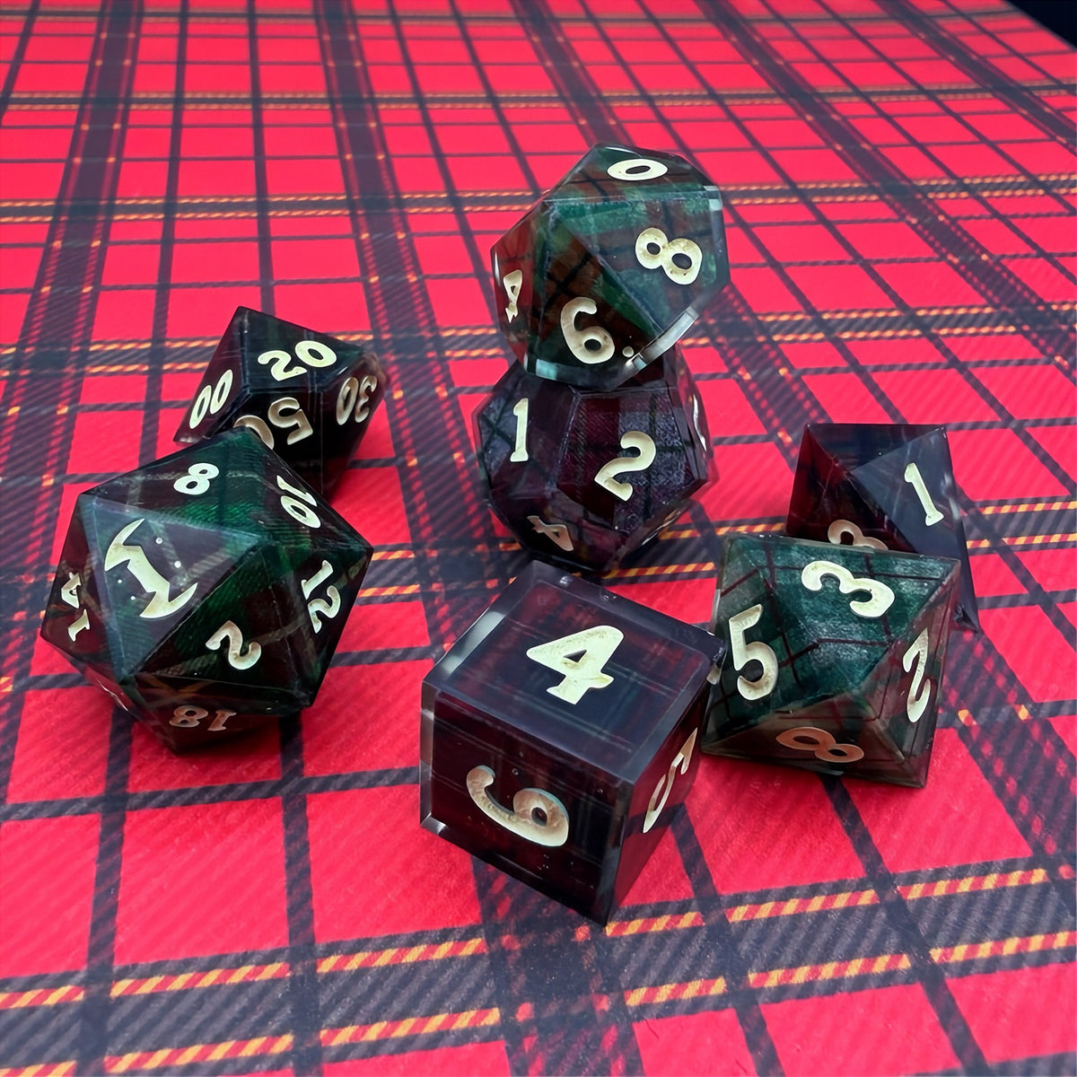 Set of polyhedral dice with red and black plaid fabric and white fur stocking background
