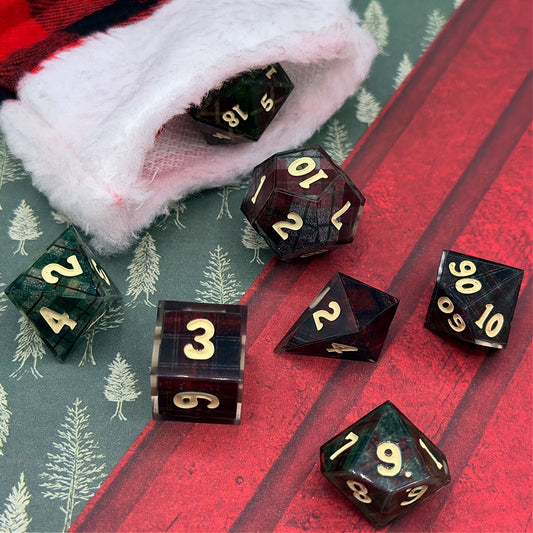 Set of polyhedral dice with red and black plaid fabric and white fur stocking background