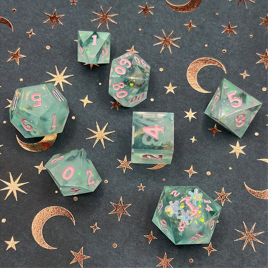 Set of green polyhedral dice with pink numbers on a dark background with star patterns