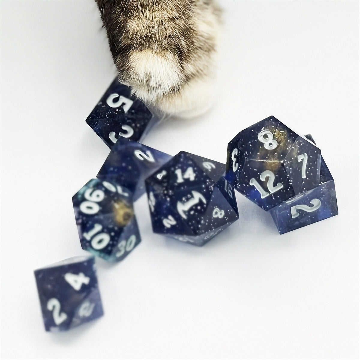 Set of polyhedral dice in a tin with star and moon pattern