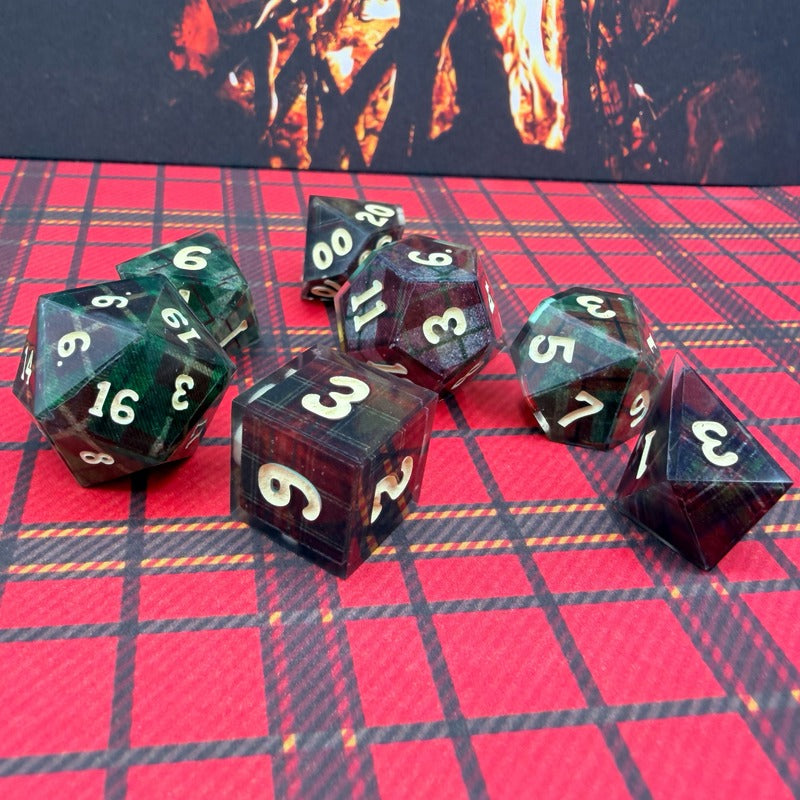 Set of polyhedral dice on a red checkered surface with a dark background