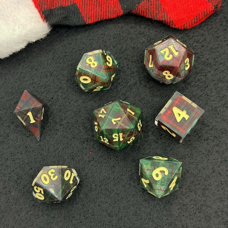 Set of polyhedral dice with green and red color scheme on a dark surface.
