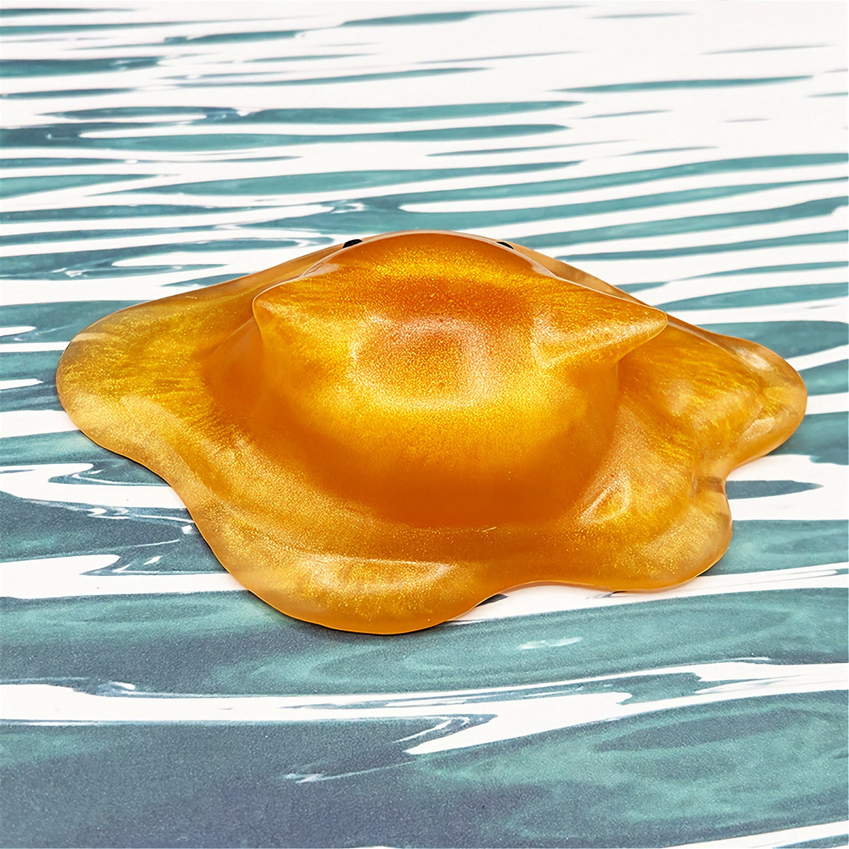 Cat-shaped resin blob on a striped background