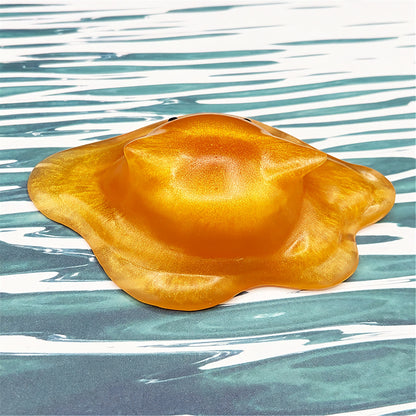 Cat-shaped resin blob on a striped background