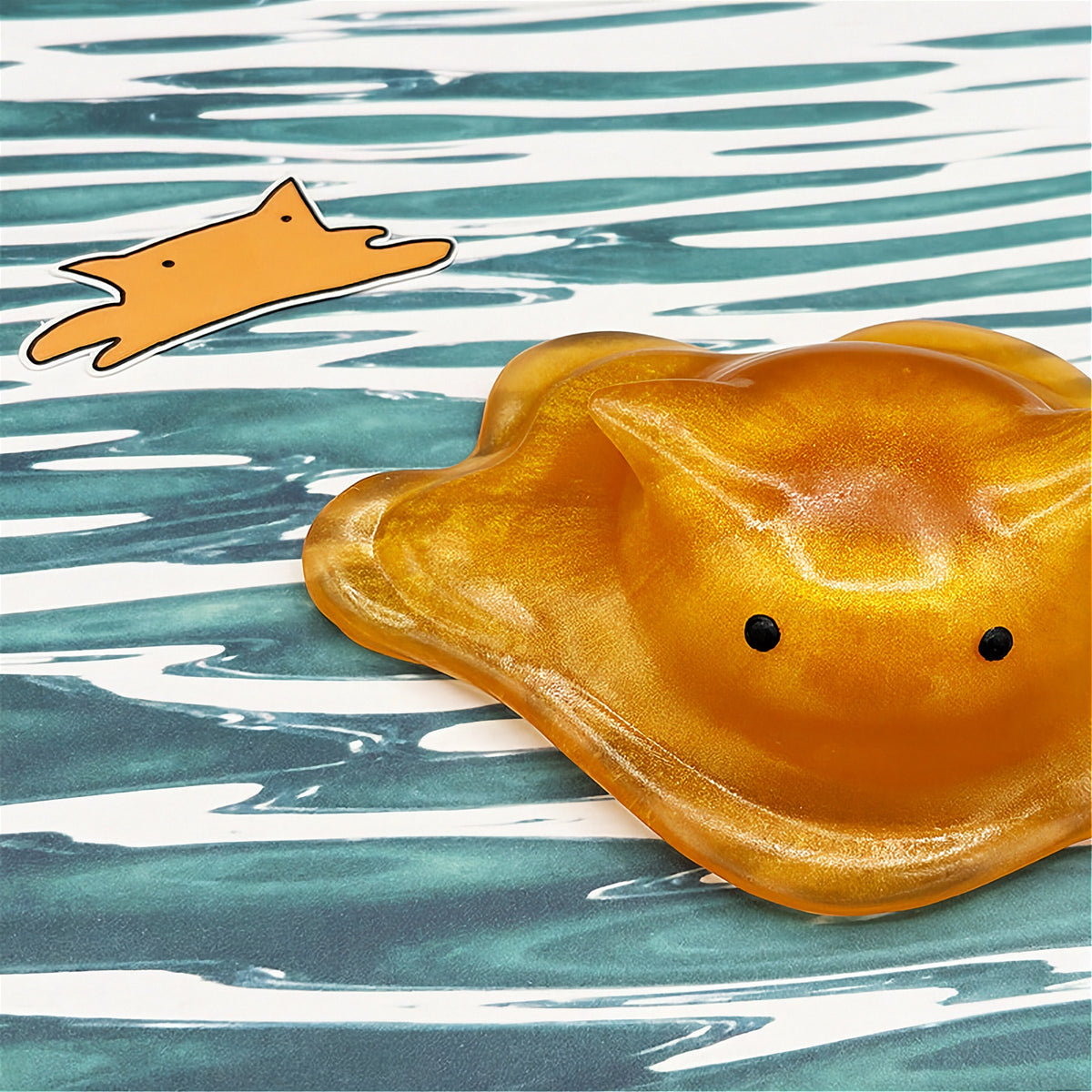 Cat-shaped resin blob on a striped background
