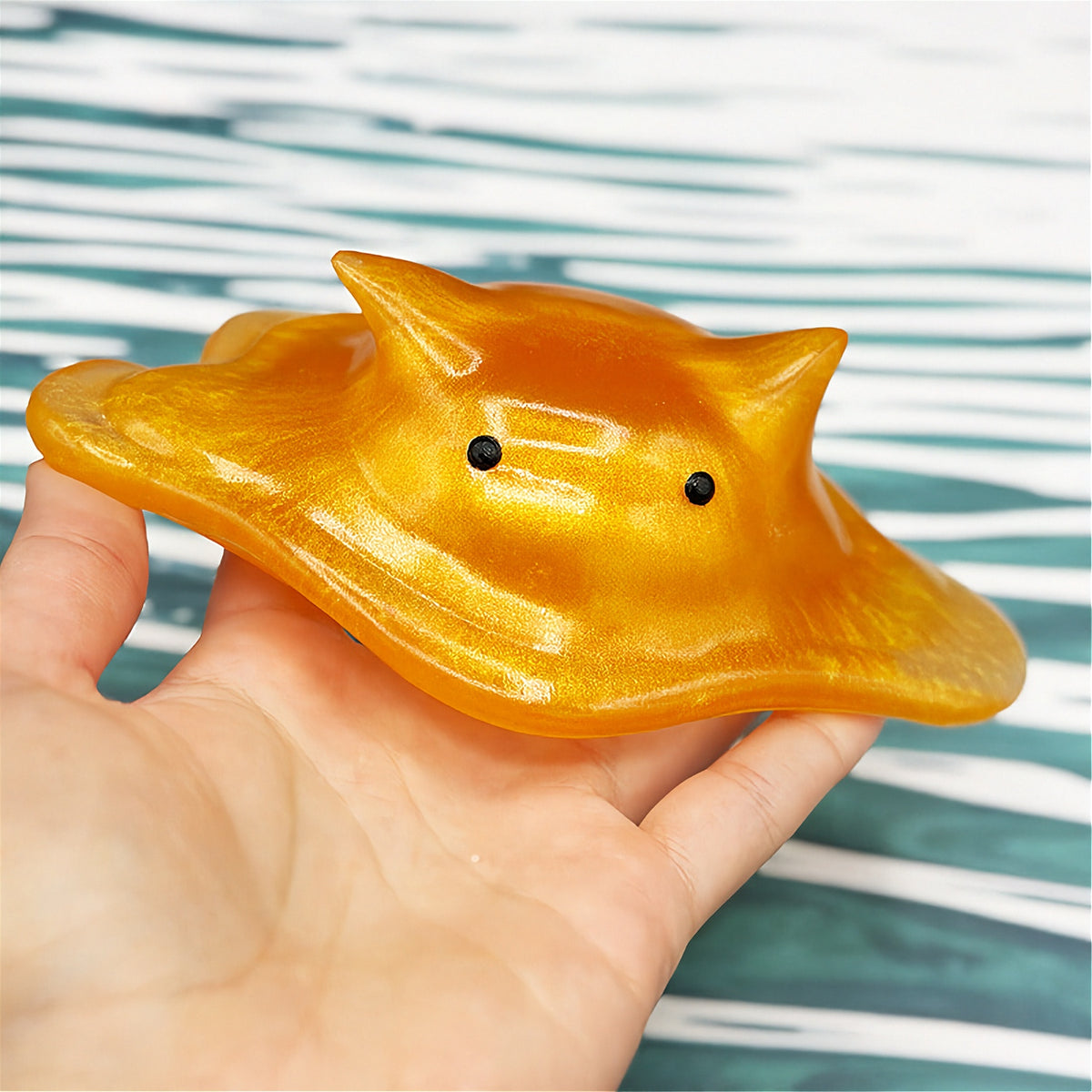 Cat-shaped resin blob on a striped background