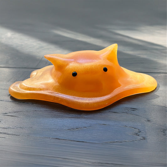 Cat-shaped resin blob on a striped background