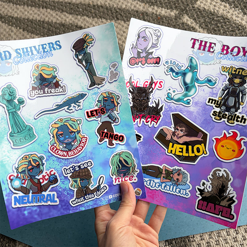 Two sheets of stickers with various characters and text held by a hand on a textured surface.