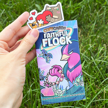 A hand holds a cartoon sticker next to a printed card pack titled "CopyCards Faithful Flock" on grass outdoors.