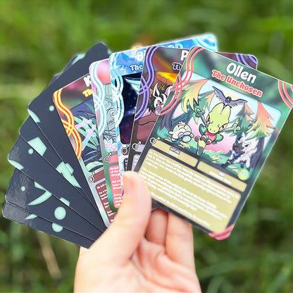 A hand holds a cartoon sticker next to a printed card pack titled "CopyCards Faithful Flock" on grass outdoors.