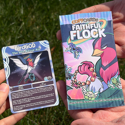 A hand holds a cartoon sticker next to a printed card pack titled "CopyCards Faithful Flock" on grass outdoors.