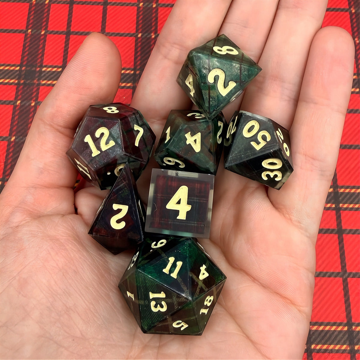 Set of polyhedral dice with red and black plaid fabric and white fur stocking background