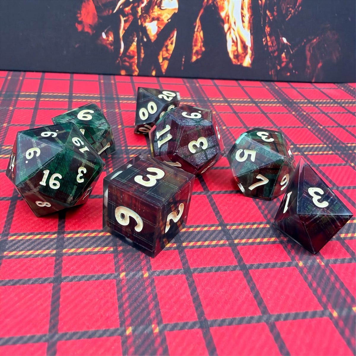 Set of polyhedral dice with red and black plaid fabric and white fur stocking background