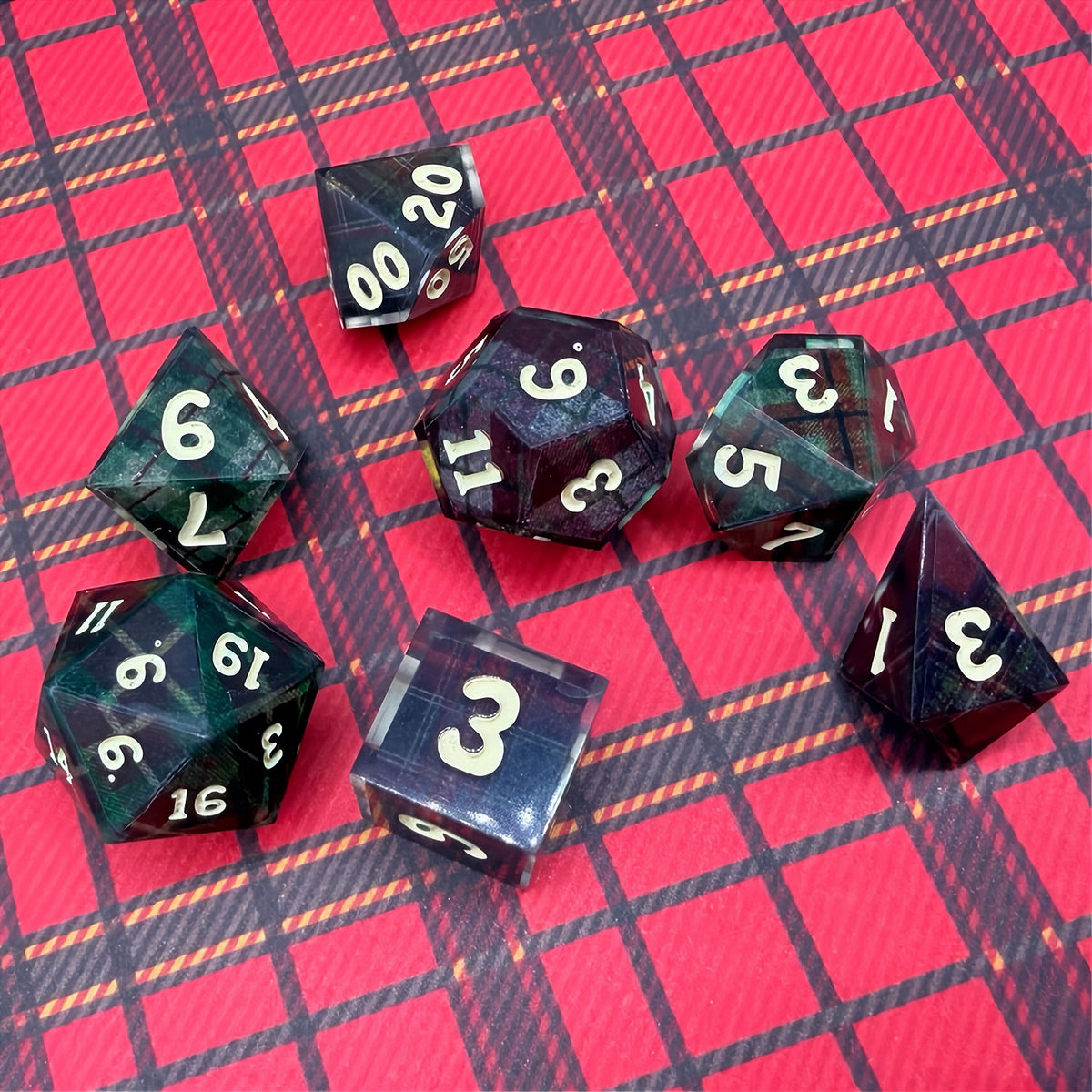 Set of polyhedral dice with red and black plaid fabric and white fur stocking background