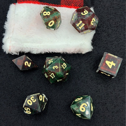 Set of polyhedral dice with red and black plaid fabric and white fur stocking background