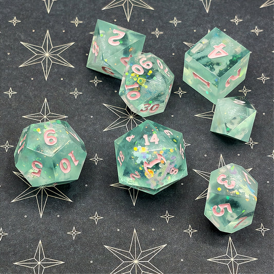 Set of green polyhedral dice with pink numbers on a dark background with star patterns
