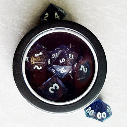 Set of polyhedral dice in a tin with star and moon pattern