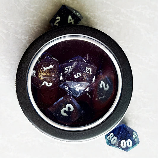 Set of polyhedral dice in a tin with star and moon pattern