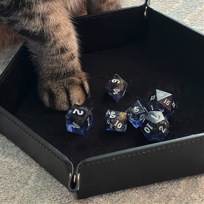 Set of polyhedral dice in a tin with star and moon pattern