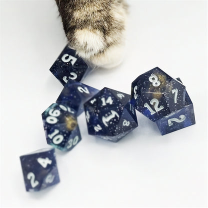 Set of polyhedral dice in a tin with star and moon pattern