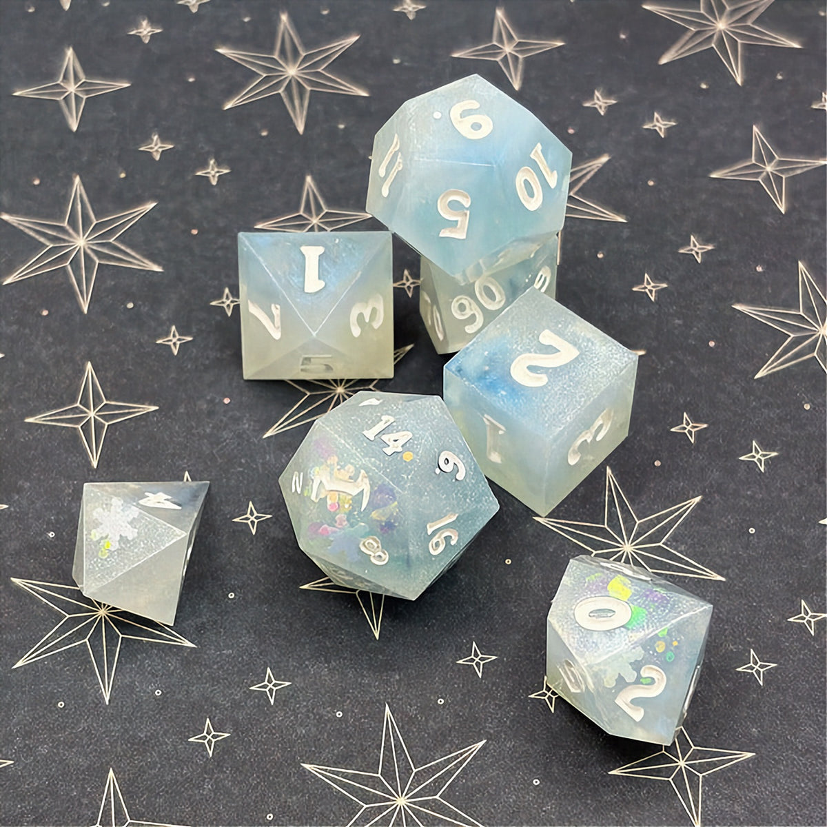 Set of light blue polyhedral dice on a dark background with star patterns