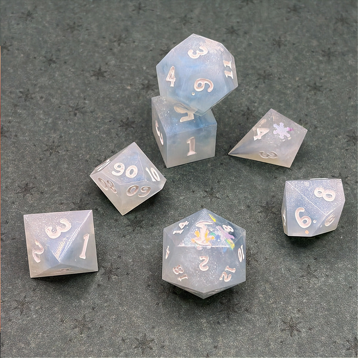 Set of light blue polyhedral dice on a dark background with star patterns