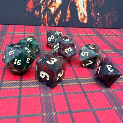 Set of polyhedral dice on a red checkered surface with a dark background