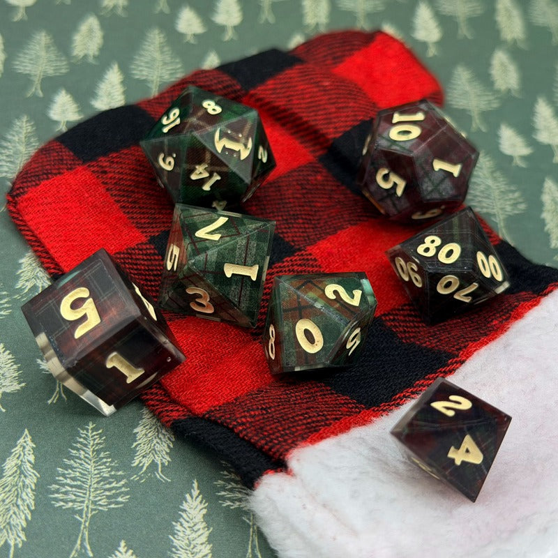 Set of polyhedral dice with red and black plaid fabric on a green background with tree pattern