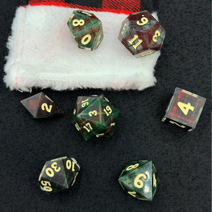 Set of green and brown dice with gold numbers on a black surface
